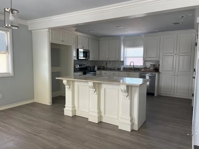 a kitchen with white cabinets and stainless steel appliances