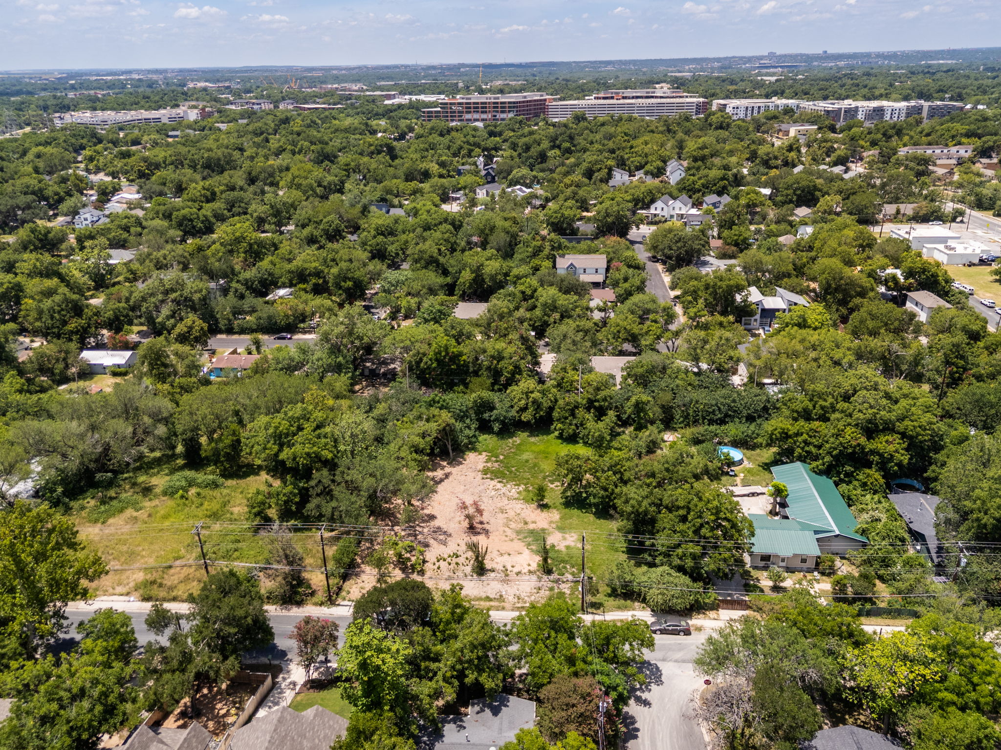 4801 Ledesma Road Austin, TX 78721 - Photo 6 of 24 An aerial perspective reveals a verdant residential landscape with scattered homes and ample undeveloped land.