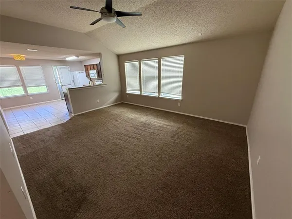 an empty room with windows and ceiling fan