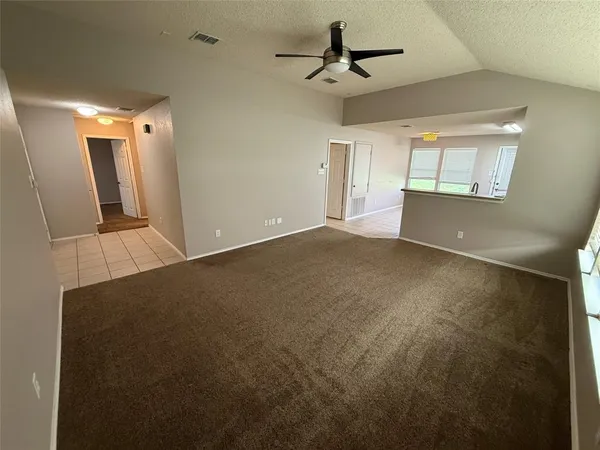 a view of a big room with wooden floor and windows