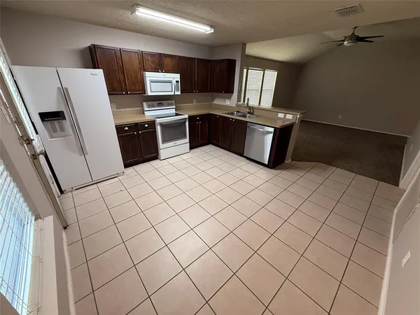a kitchen with stainless steel appliances a refrigerator and a stove top oven