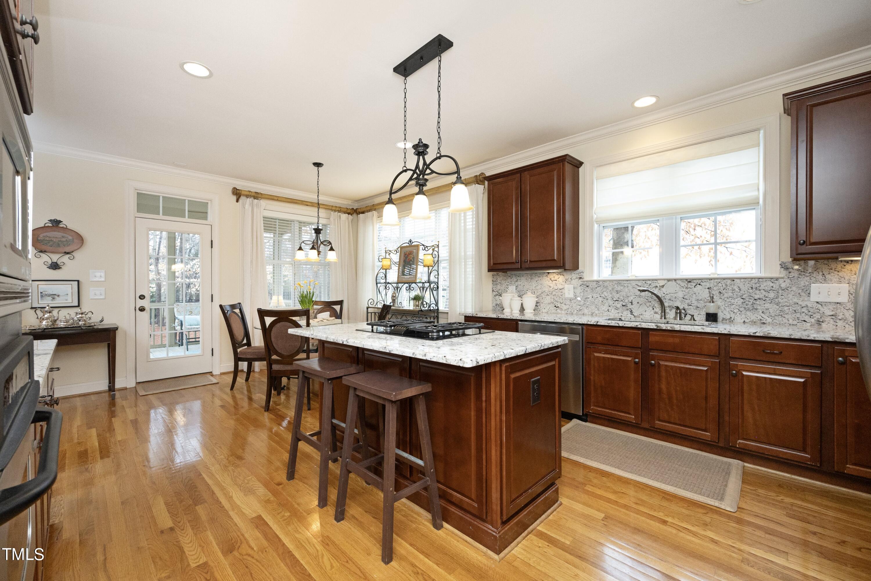 11514 Autumn Oaks Lane Raleigh, NC 27614 - Photo 14 of 39 a kitchen with stainless steel appliances granite countertop a stove a sink dishwasher a dining table and chairs with wooden floor