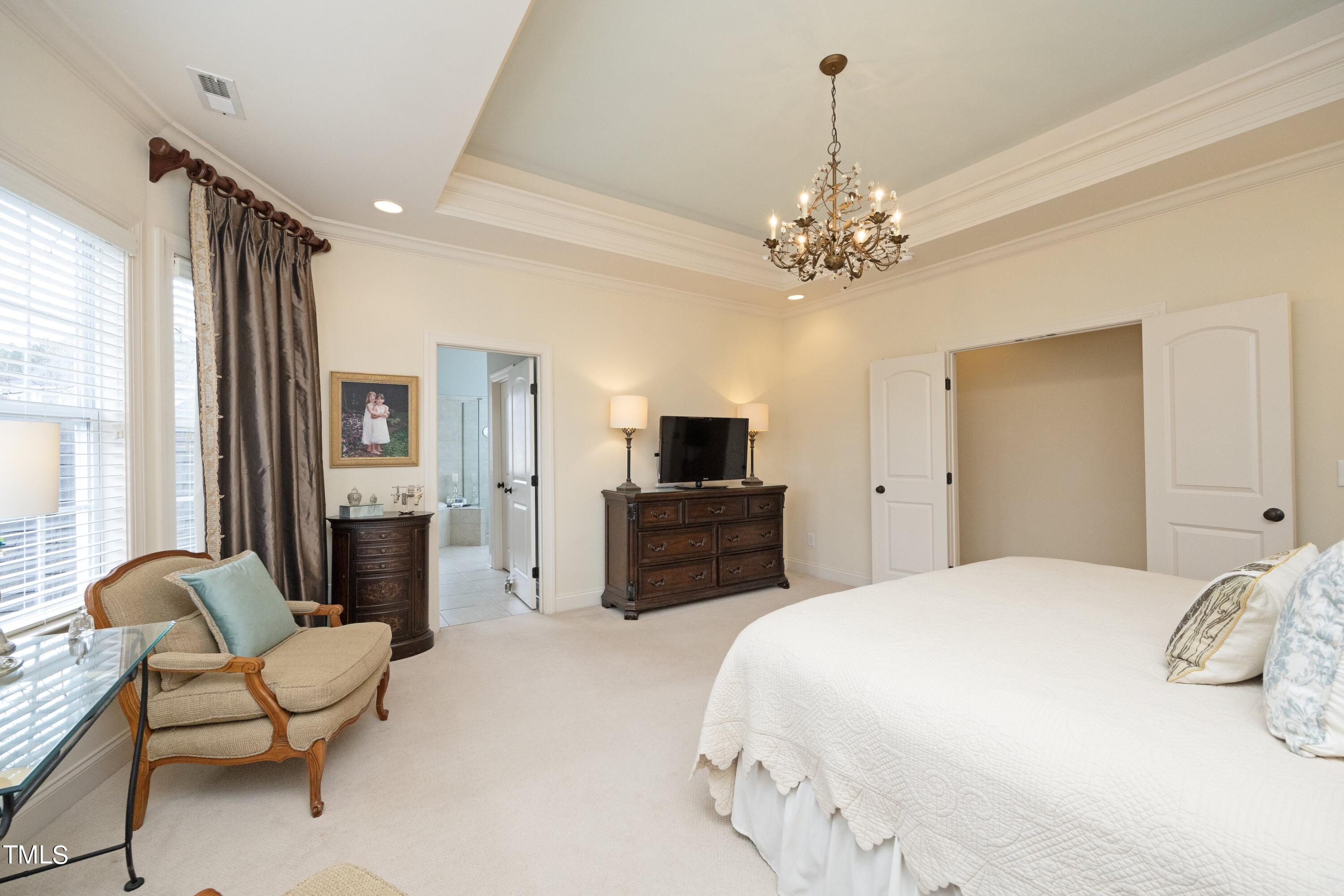 11514 Autumn Oaks Lane Raleigh, NC 27614 - Photo 23 of 39 a spacious bedroom with a bed and a chandelier
