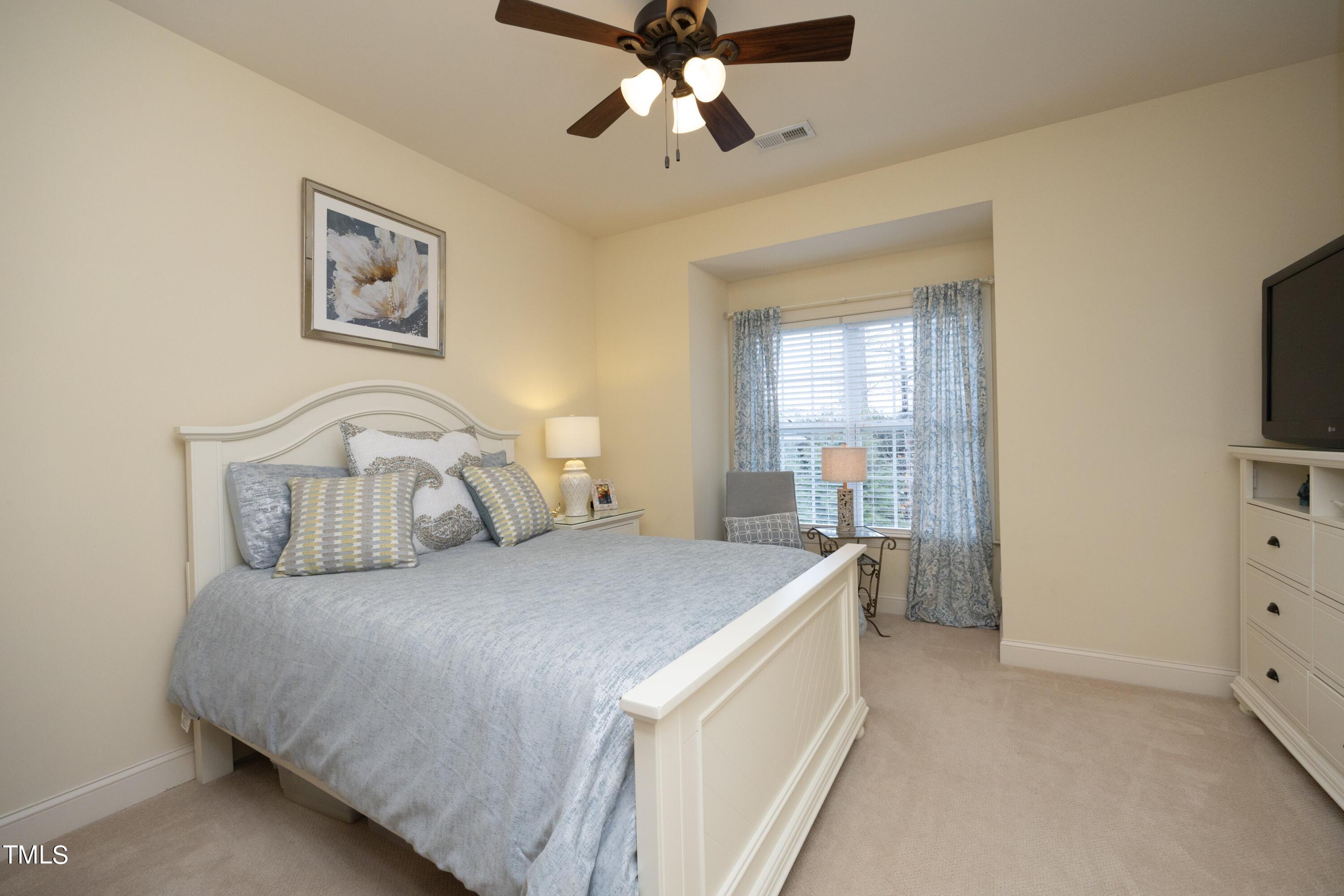 11514 Autumn Oaks Lane Raleigh, NC 27614 - Photo 30 of 39 a bedroom with a bed and a flat tv screen on dresser