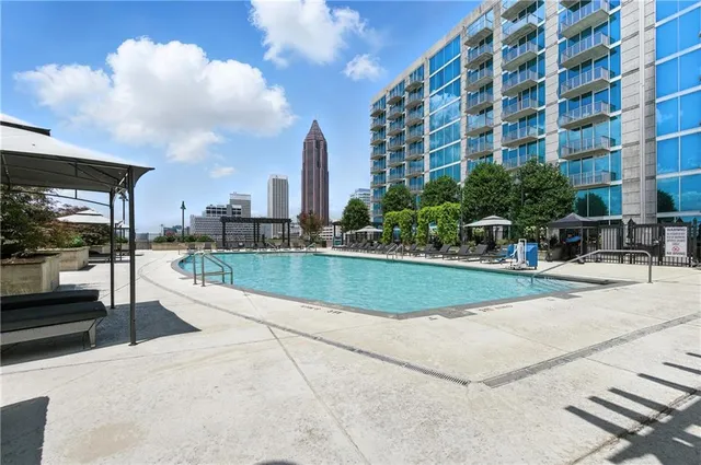 a living room with furniture a large window and a rug