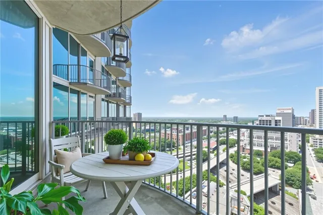 a roof deck with table and chairs and potted plants