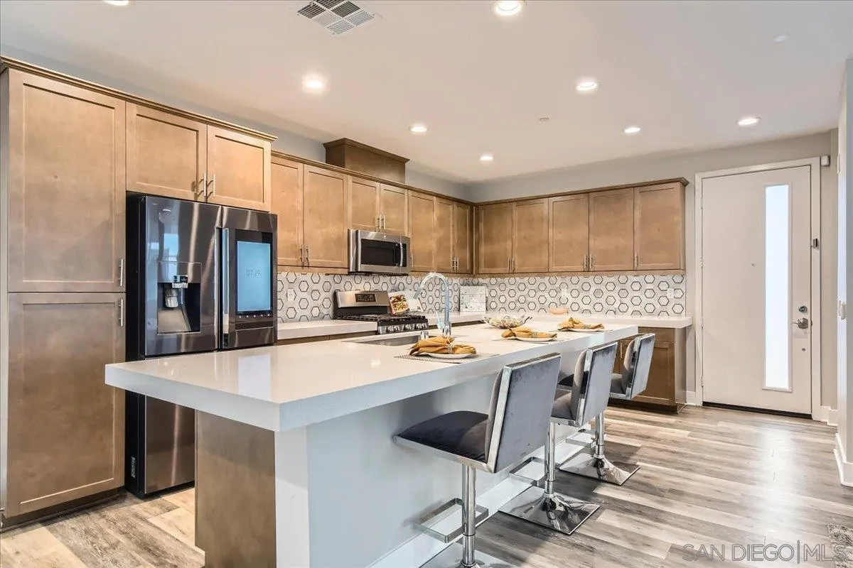 2290 Element Way Chula Vista, CA 91915 - Photo 4 of 34 a kitchen with kitchen island a appliances dining table and chairs