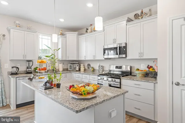 a kitchen with stainless steel appliances granite countertop a sink stove and cabinets