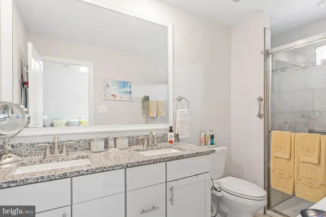 a bathroom with a granite countertop sink a toilet and a mirror