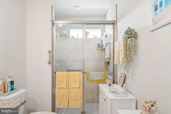 a bathroom with a granite countertop shower a mirror and a sink