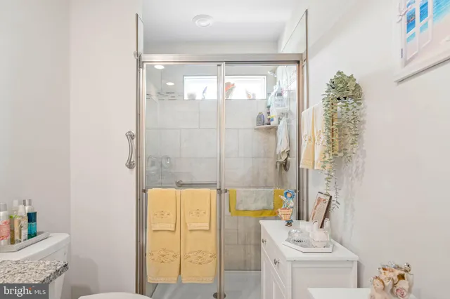 a bathroom with a granite countertop shower a mirror and a sink