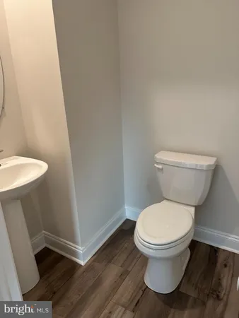 a white toilet sitting next to a white sink and vanity