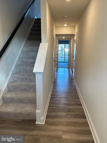 a view of entryway and hall with wooden floor