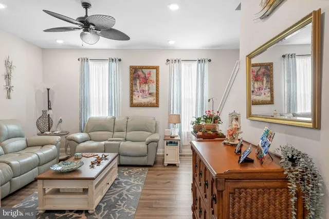 a living room with furniture ceiling fan and a window