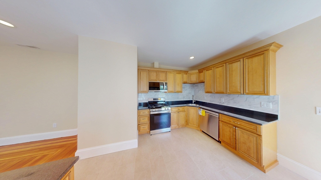 27 Champney Street, Unit 2 Boston, MA 02135 - Photo 5 of 12 a kitchen with stainless steel appliances granite countertop a stove and a refrigerator