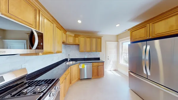 a kitchen with stainless steel appliances granite countertop a refrigerator and a stove