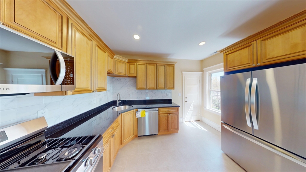 27 Champney Street, Unit 2 Boston, MA 02135 - Photo 6 of 12 a kitchen with stainless steel appliances granite countertop a refrigerator and a stove