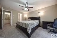 a spacious bedroom with a bed and a chandelier