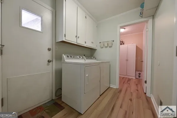 a utility room with wooden floor washer and dryer