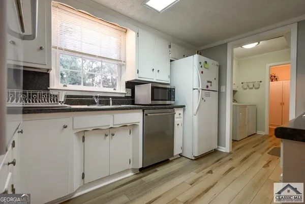 a kitchen with white cabinets and white appliances