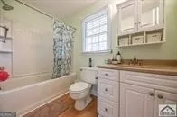 a bathroom with a granite countertop toilet a sink and a bathtub