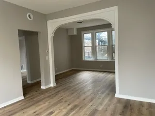 an empty room with wooden floor and a window