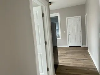 a view of a hallway with wooden floor