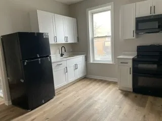 a kitchen with a refrigerator and a stove top oven