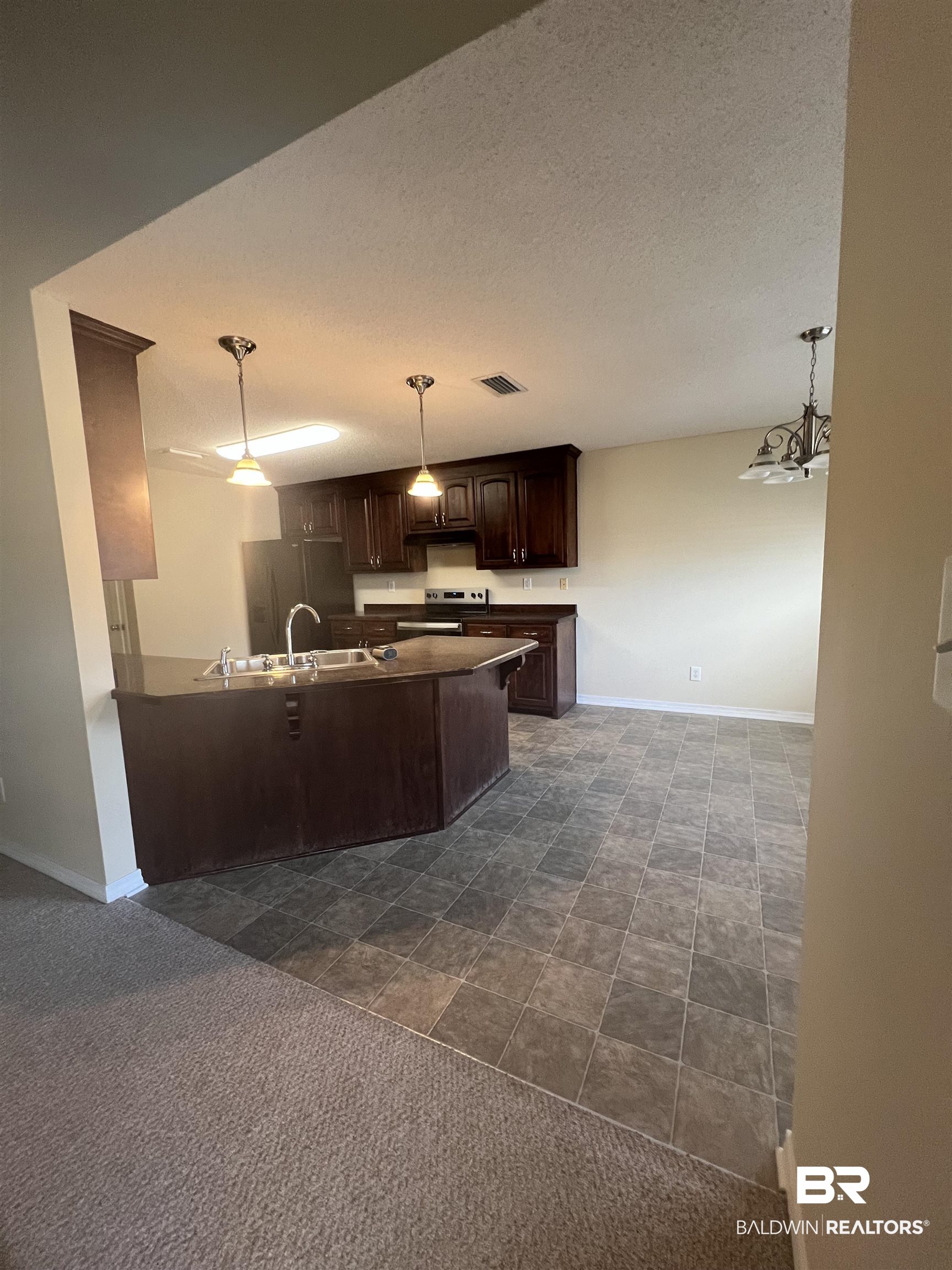 17793 Fancy Boulevard Foley, AL 36535 - Photo 5 of 34 Kitchen featuring sink, stainless steel electric range, dark brown cabinets, decorative light fixtures, and kitchen peninsula