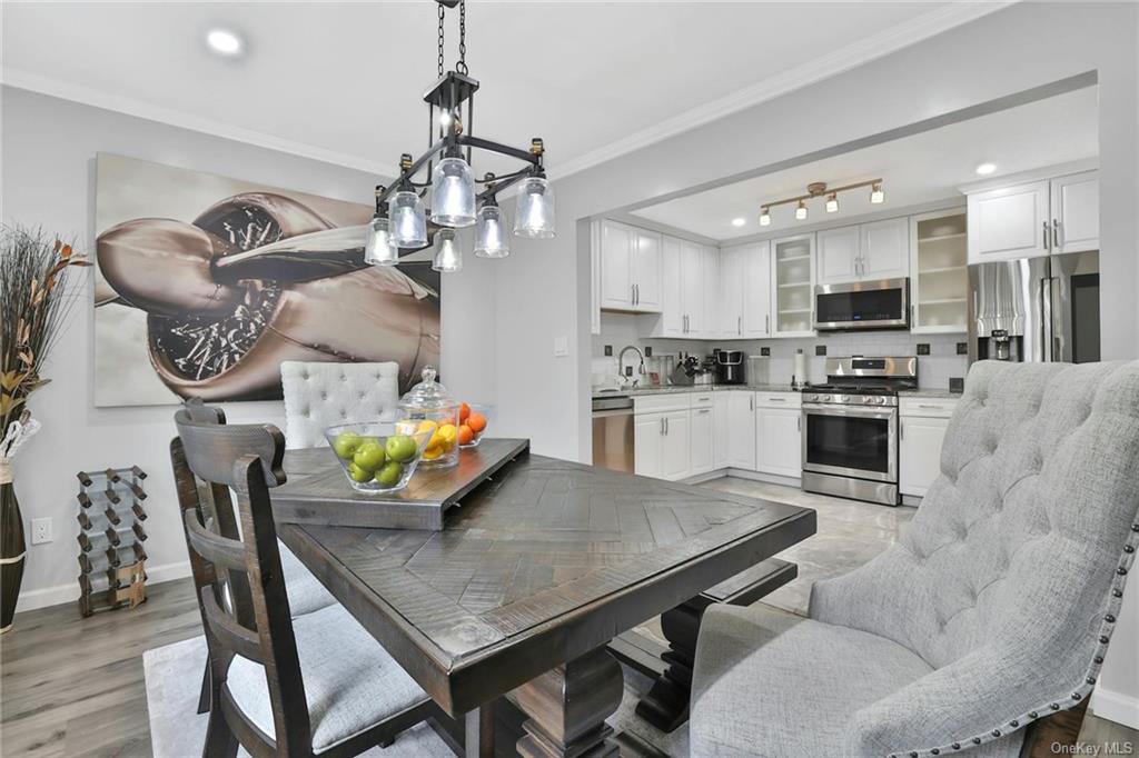 a kitchen with granite countertop stainless steel appliances a dining table and chairs