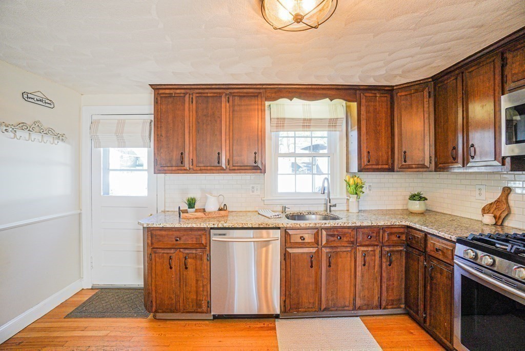 71 Pine Ridge Road Reading, MA 01867 - Photo 3 of 40 a kitchen with stainless steel appliances granite countertop a sink stove and cabinets