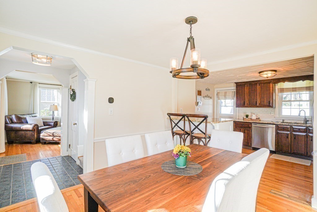71 Pine Ridge Road Reading, MA 01867 - Photo 7 of 40 a dining room with wooden floor a chandelier a wooden table and chairs
