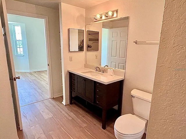 a bathroom with a toilet a sink and mirror