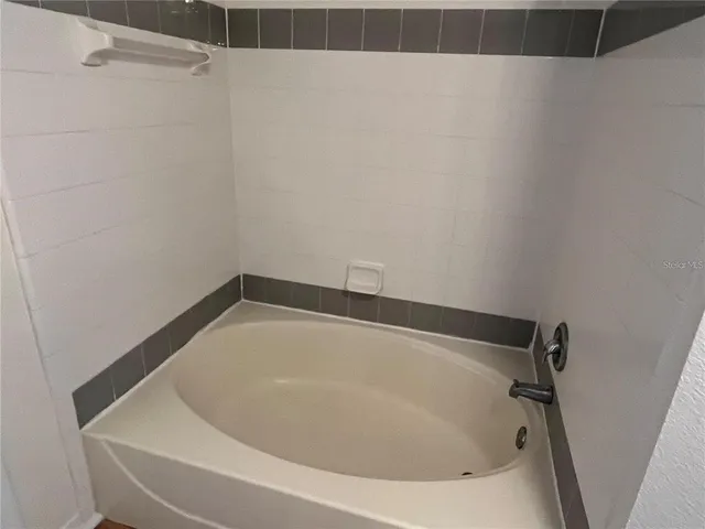 a bathroom with a white bath tub and a shower