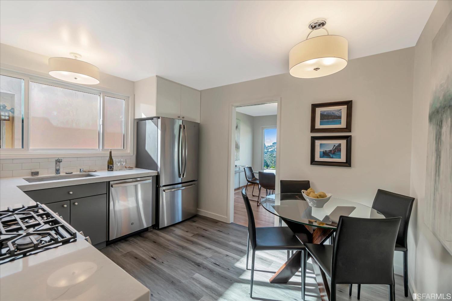 159 Skyview Way San Francisco, CA 94131 - Photo 9 of 17 a kitchen with stainless steel appliances granite countertop a stove a refrigerator a sink dishwasher a dining table and chairs with wooden floor