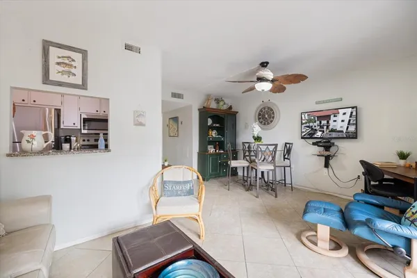 a living room with furniture chess floor and a chandelier