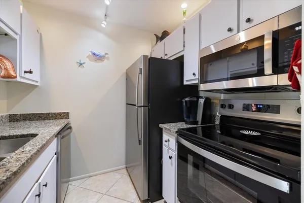 a kitchen with stainless steel appliances granite countertop a refrigerator and a stove top oven