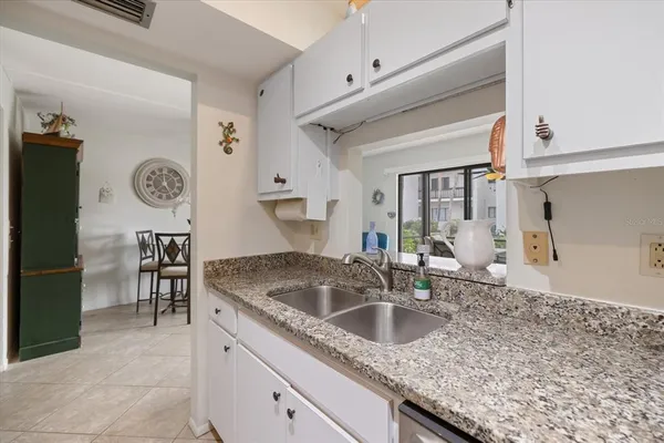a kitchen with stainless steel appliances granite countertop a sink and a refrigerator