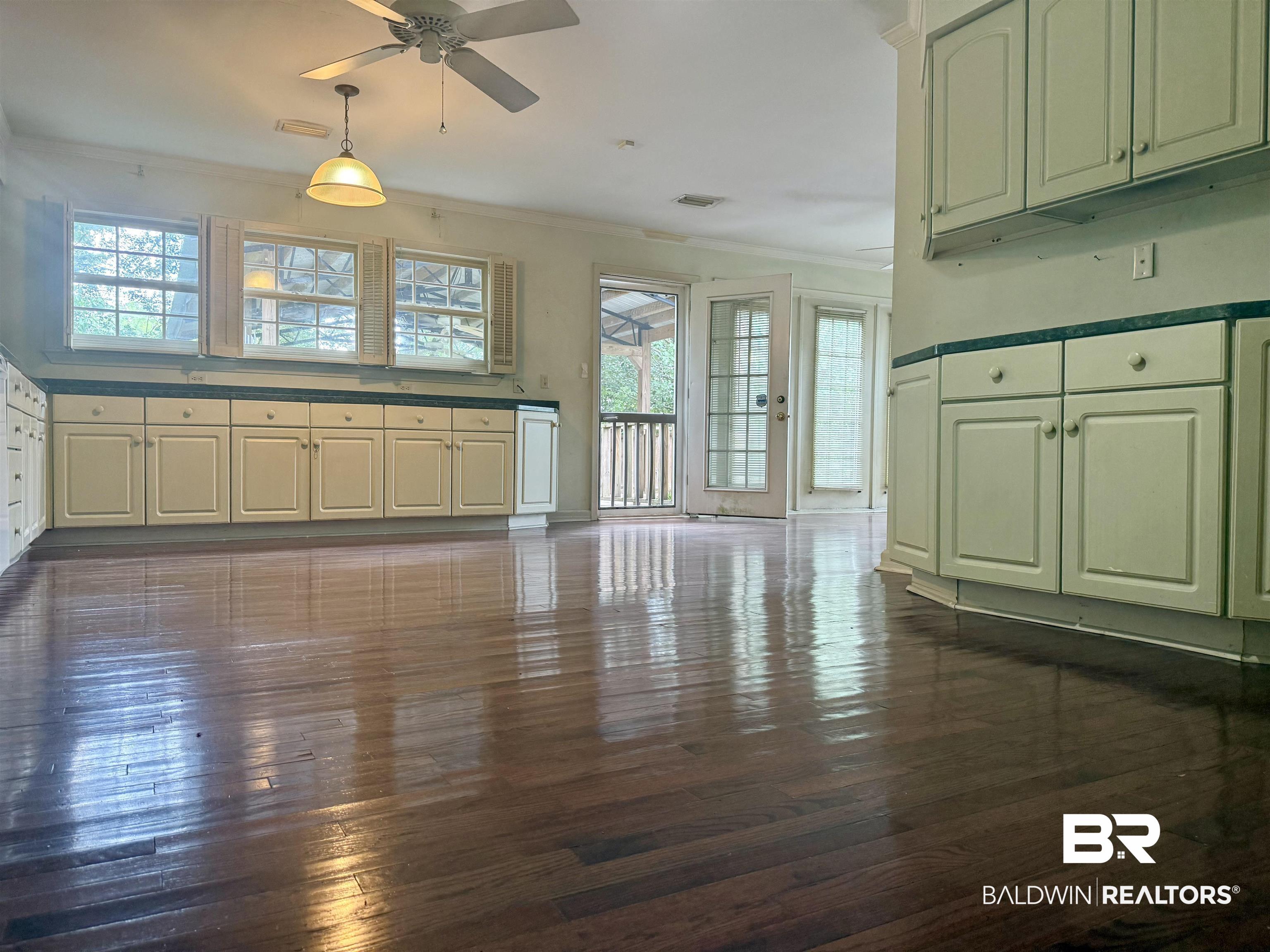 1412 Poplar Avenue Brewton, AL 36426 - Photo 11 of 32 Kitchen featuring ceiling fan, crown molding, dark wood-style floors, healthy amount of natural light, and hanging light fixtures