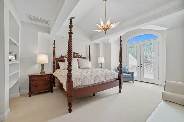 a bedroom with bed and a chandelier