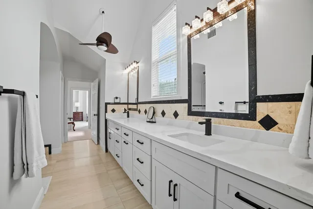a spacious bathroom with a tub sink and mirror