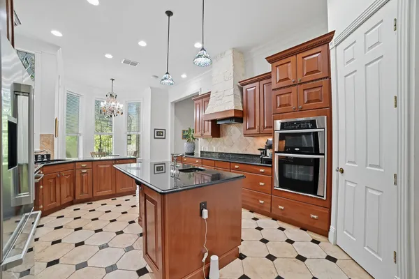 a kitchen with stainless steel appliances a sink a stove a refrigerator and cabinets