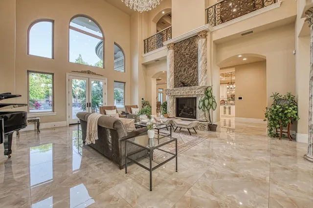a living room with furniture a fireplace and potted plants