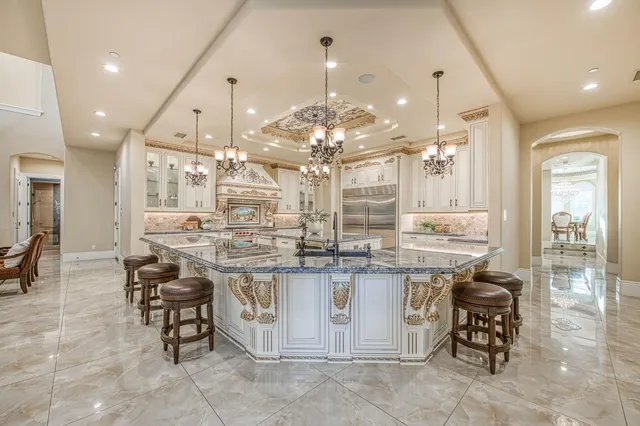 a kitchen with cabinets and chairs