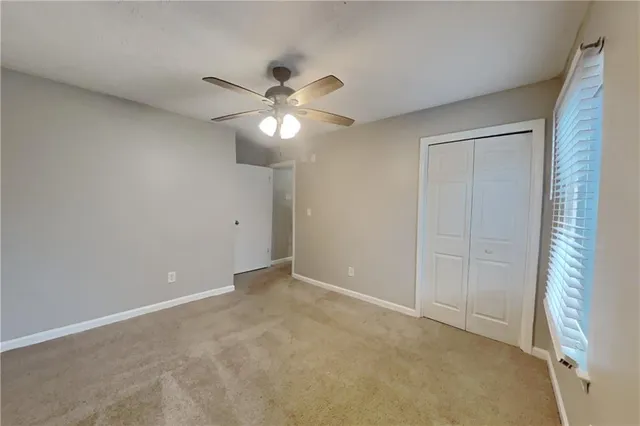 an empty room with a window and a fan