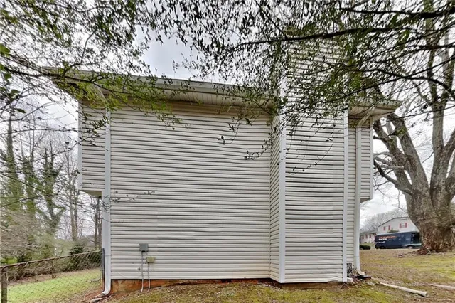 a view of a white house with a white door and wooden fence