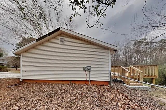 a backyard of a house with wooden fence and large trees
