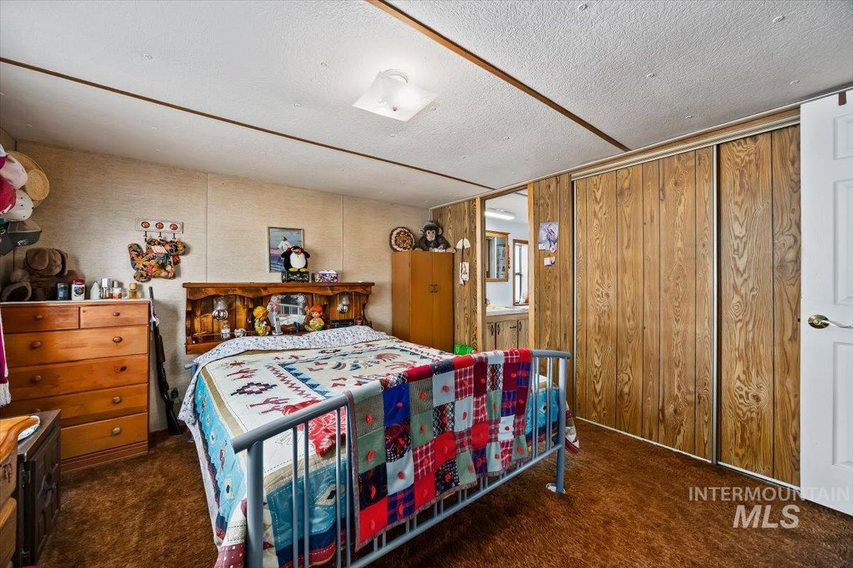 102 Willow Creek Road Fairfield, ID 83327 - Photo 15 of 32 Bedroom featuring a textured ceiling and dark carpet
