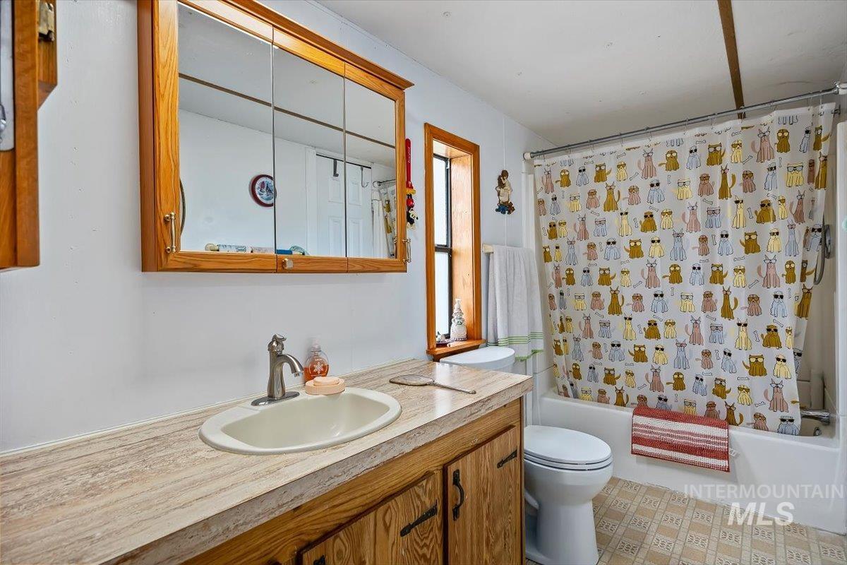 102 Willow Creek Road Fairfield, ID 83327 - Photo 16 of 32 Full bath with vanity, shower / bathtub combination with curtain, and light flooring
