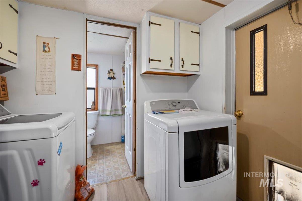 102 Willow Creek Road Fairfield, ID 83327 - Photo 18 of 32 Laundry room featuring cabinet space, light flooring, and independent washer and dryer